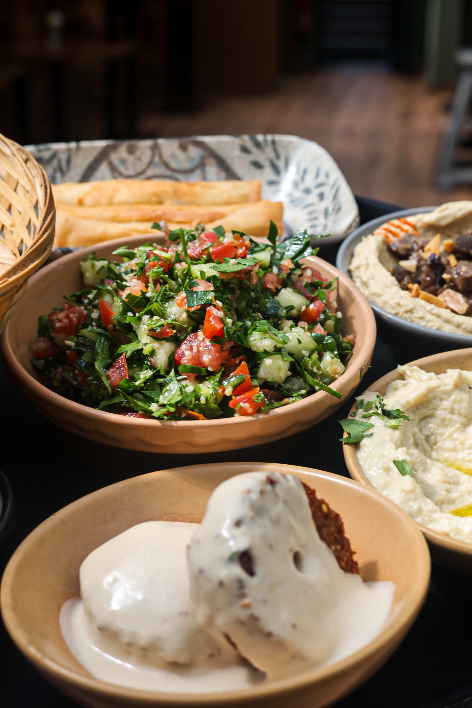 Close-up food photography of tabbouleh and mezze dishes served in a restaurant